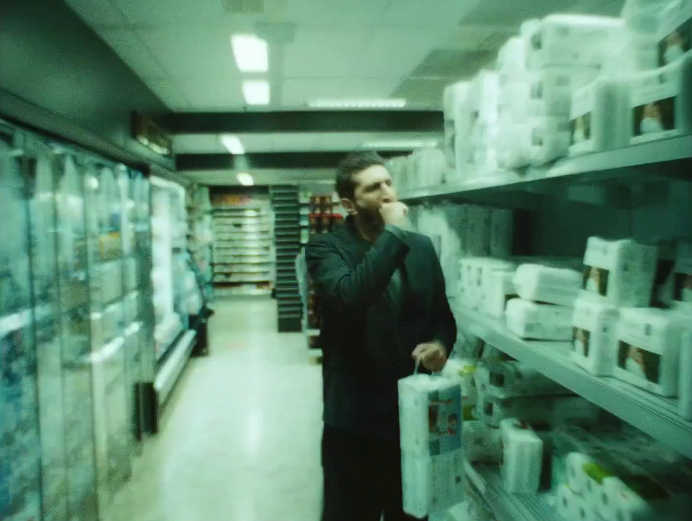 a man standing in a store holding a plastic bag