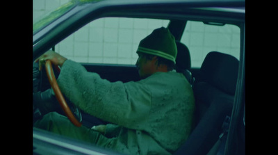 a man in a green uniform driving a car