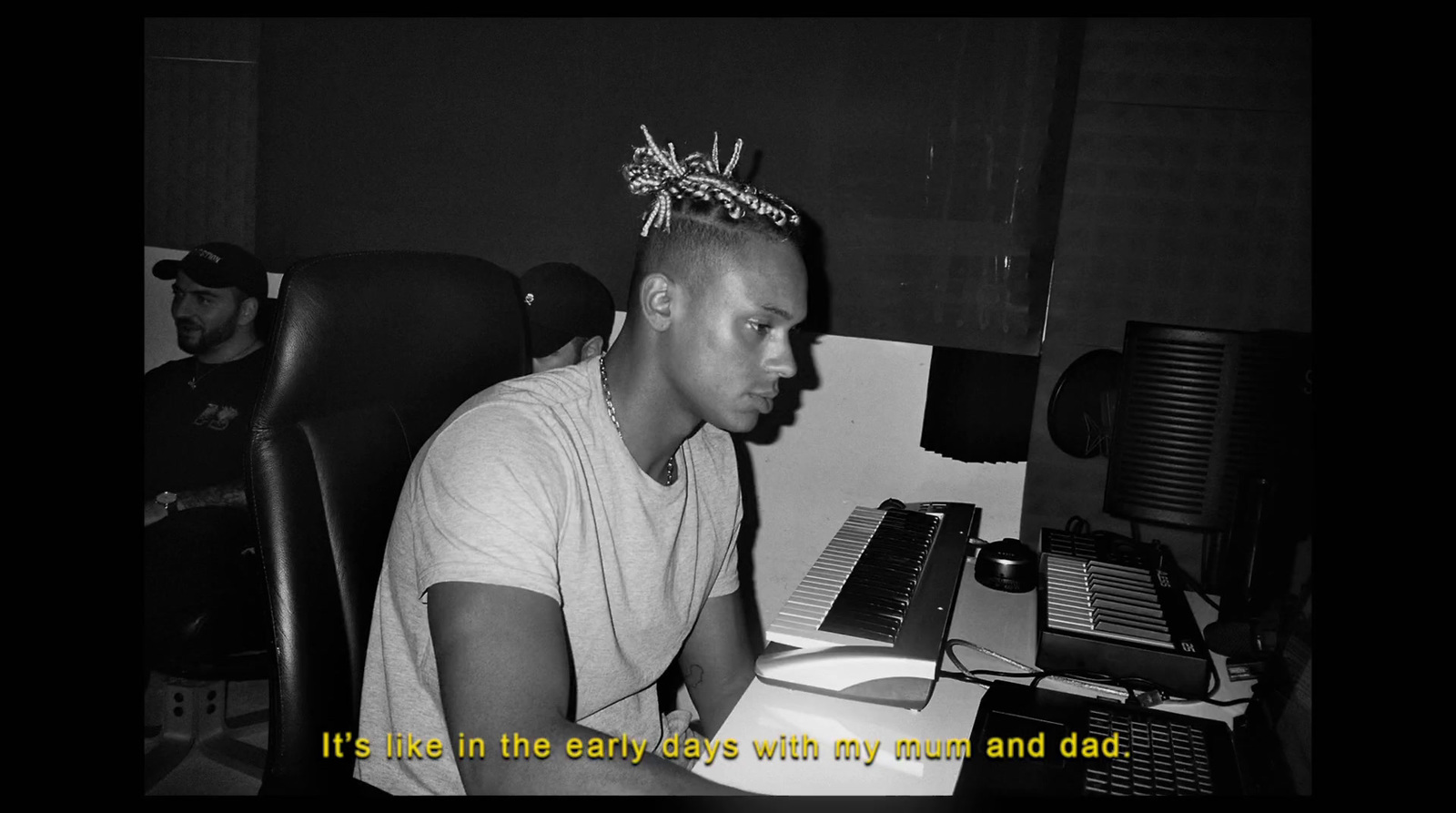 a man sitting at a computer desk with a crown on his head