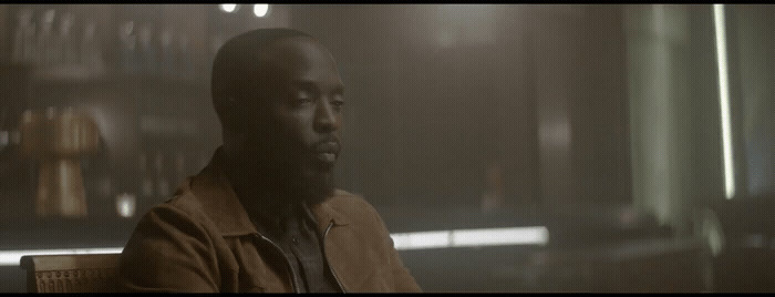 a man sitting on a bench in a dimly lit room