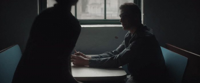 a man sitting at a table in front of a window