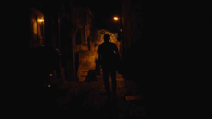 a man standing in a dark alley at night