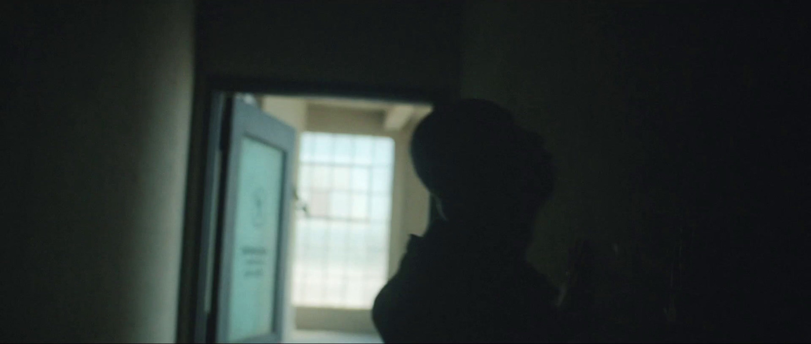 a silhouette of a person standing in a dark room