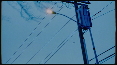 a telephone pole with a street light in the background