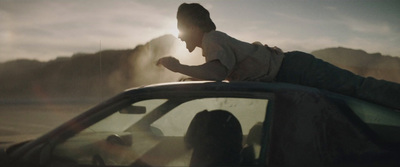 a person sitting on the hood of a car