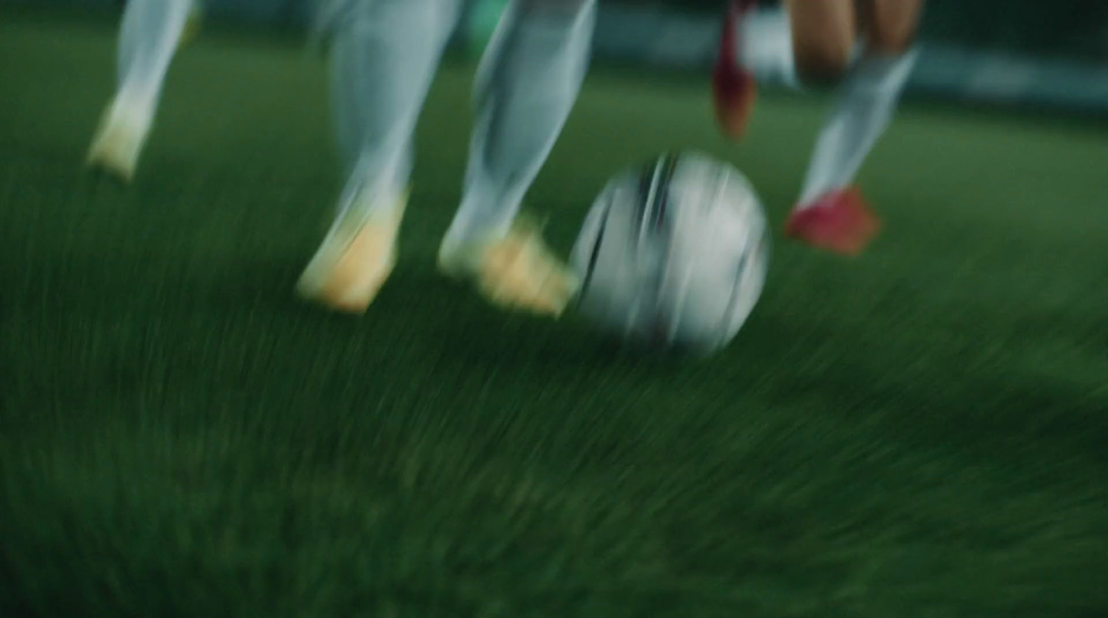 a group of people kicking around a soccer ball on a field