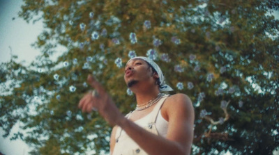 a man in a white tank top blowing bubbles