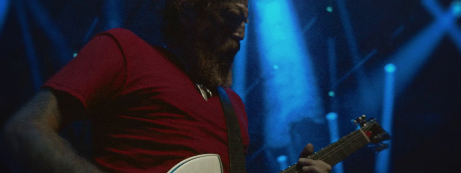 a man with a beard playing a guitar