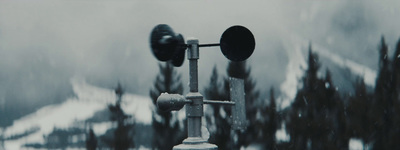 a traffic light sitting in the middle of a snow covered forest