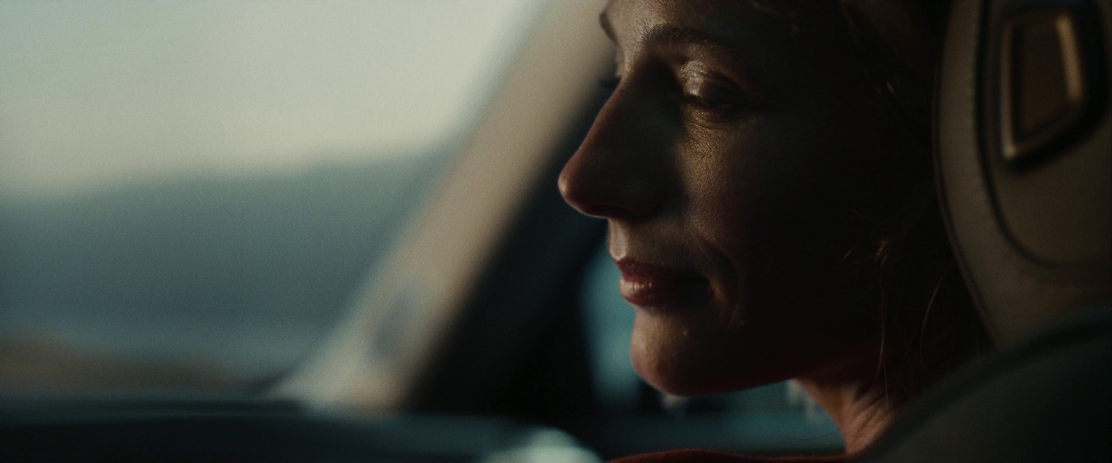 a woman sitting in a car looking out the window