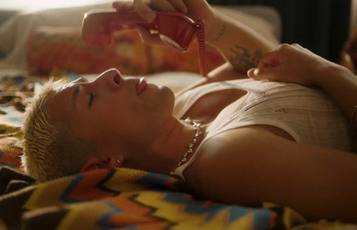 a woman laying on a bed talking on a phone