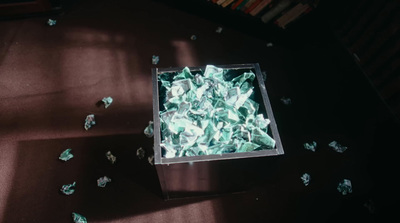 a box filled with green tissue paper on top of a table