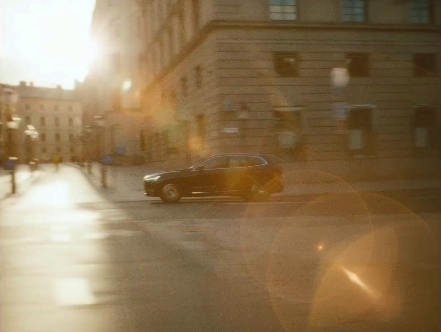 a car driving down a street next to tall buildings