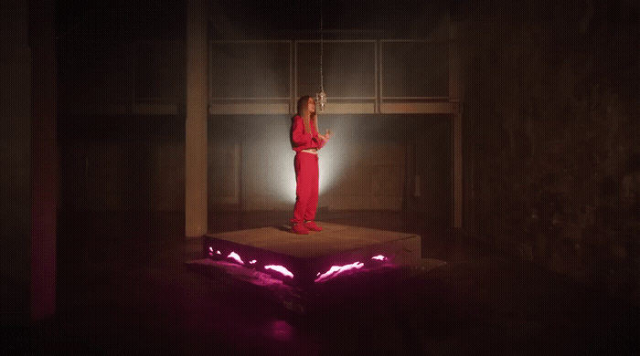 a woman in a red outfit standing on a platform