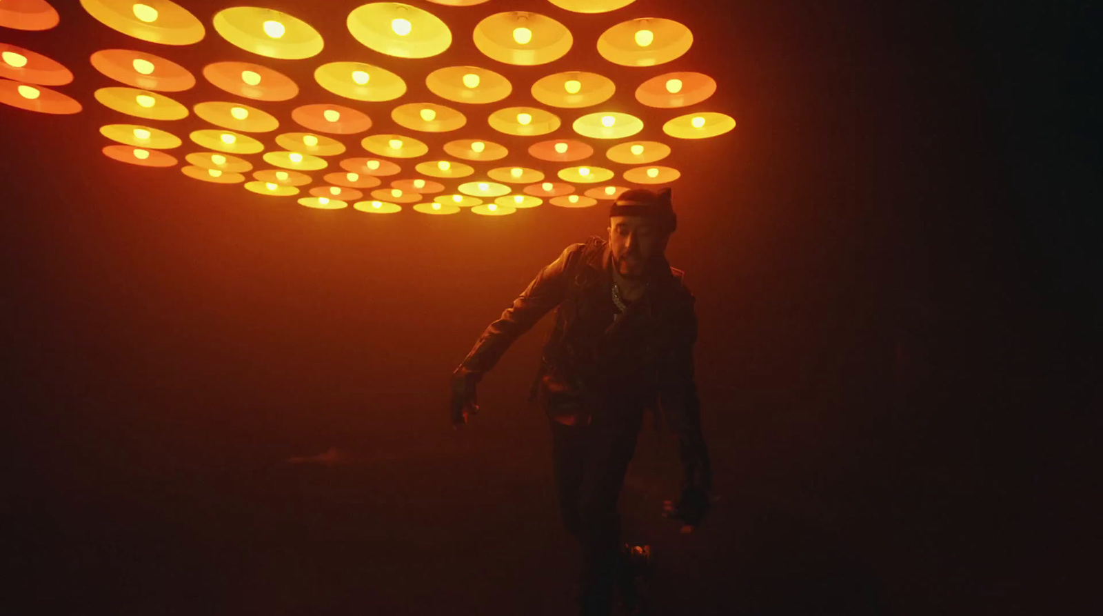 a woman is standing under a light fixture