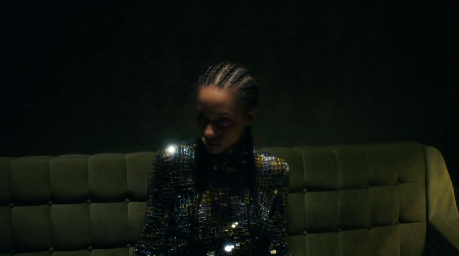 a woman sitting on a couch in a dark room