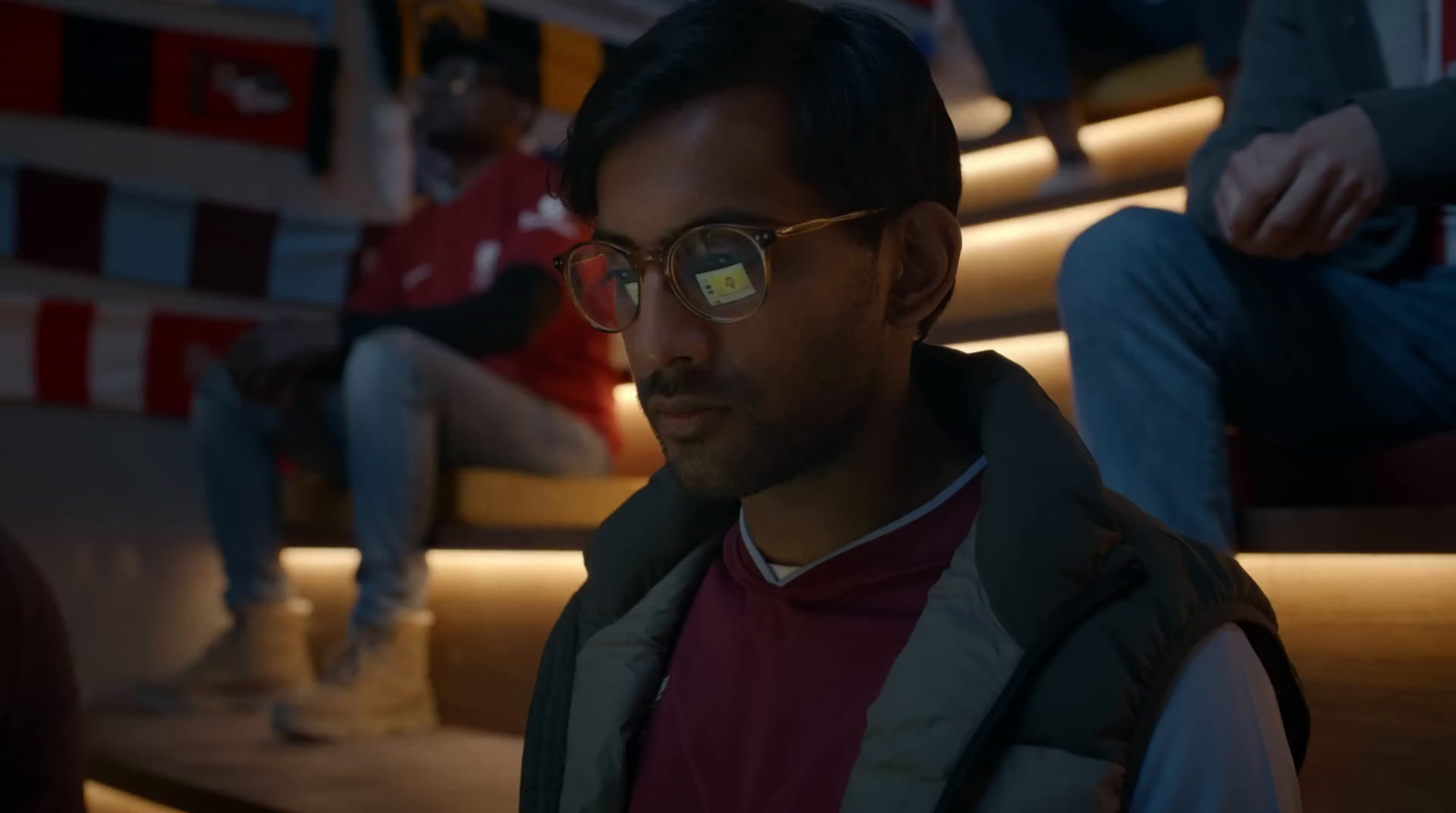 a man wearing glasses sitting on a set of stairs