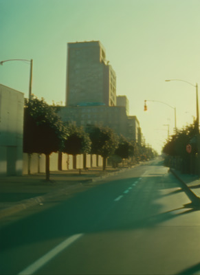 a city street with tall buildings in the background