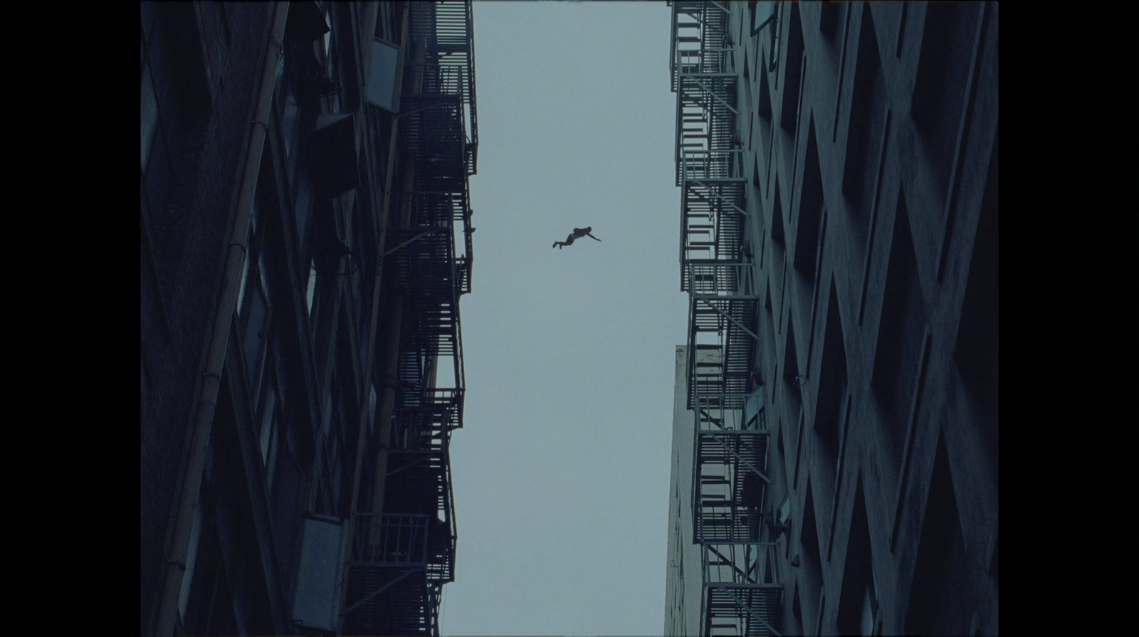 an airplane flying over a city with tall buildings