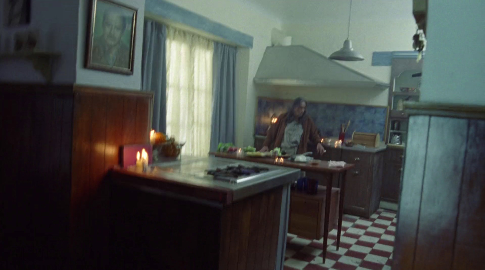 a man standing in a kitchen next to a stove top oven