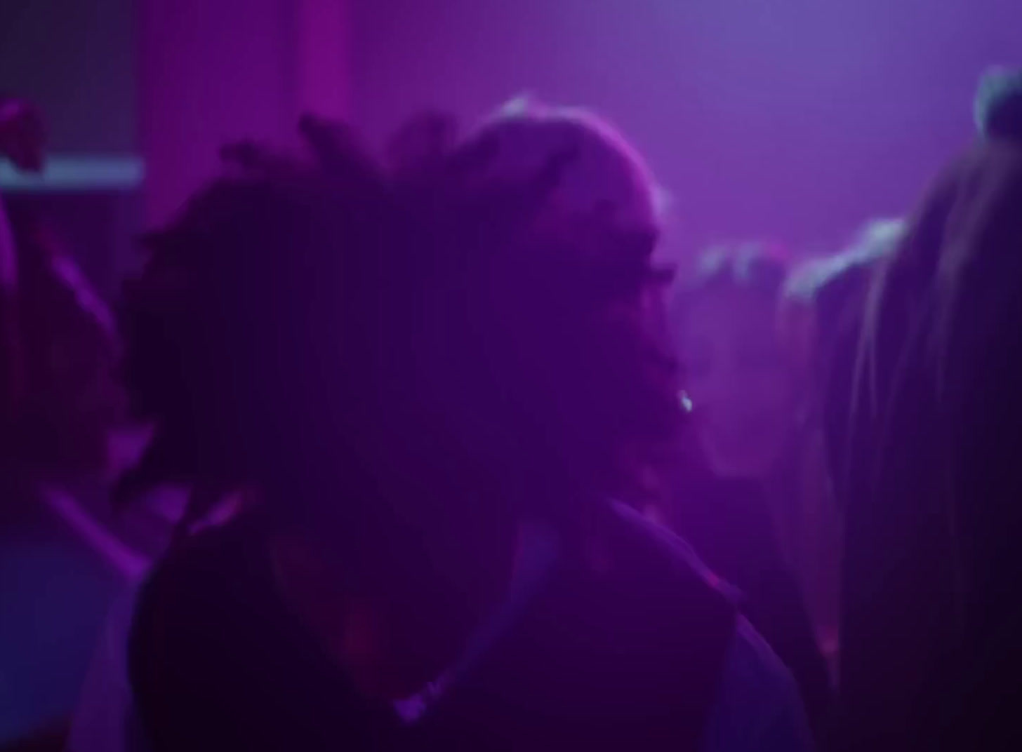 a woman with dreadlocks standing in a dark room