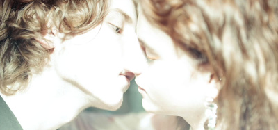 a close up of a person kissing another person