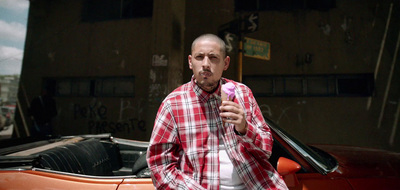 a man standing next to a car holding a microphone