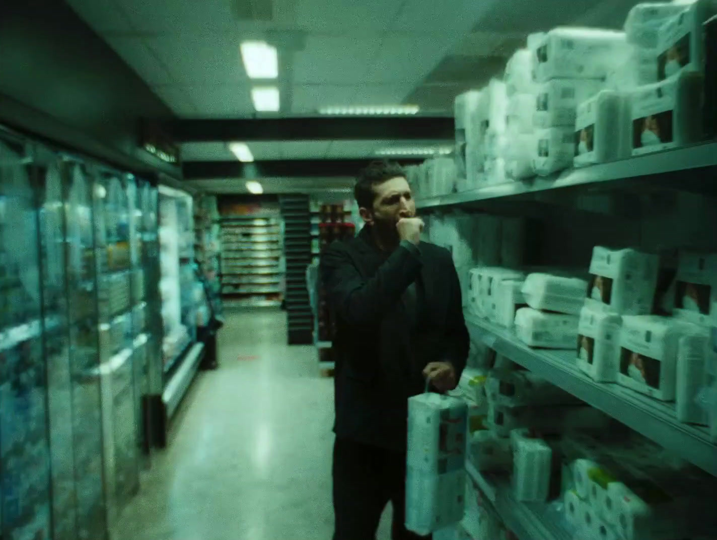 a man standing in a store holding a plastic container