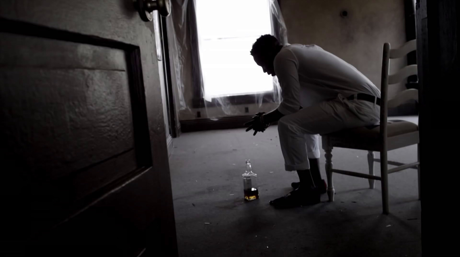 a man sitting in a chair with a bottle of alcohol