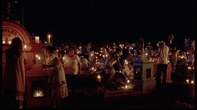 a group of people standing around a table covered in candles