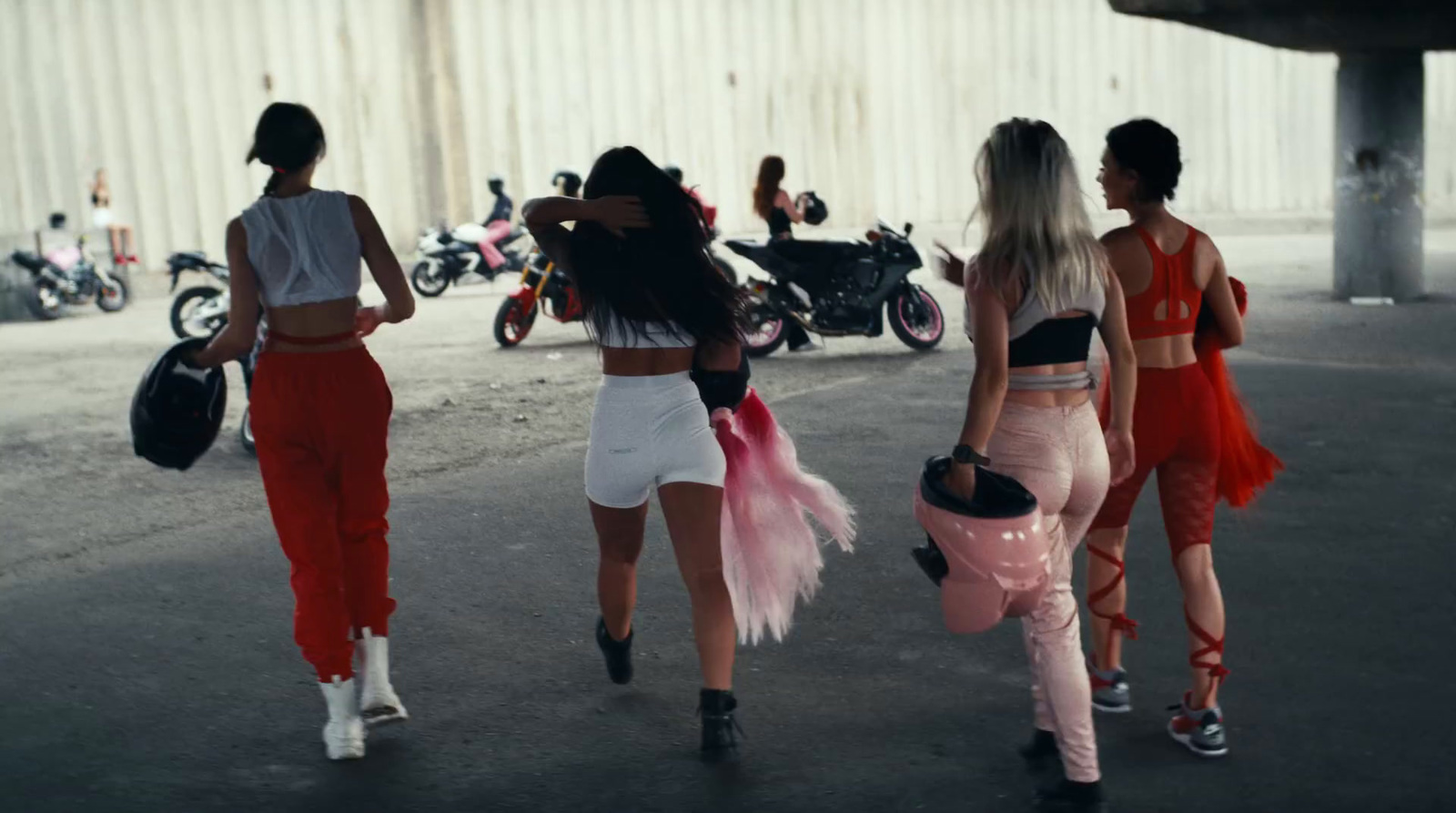 a group of women walking down a street next to motorcycles