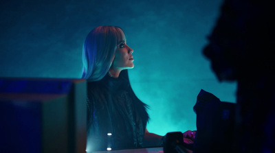 a woman sitting at a desk in a dark room