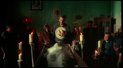 a group of people standing around a bed in a room