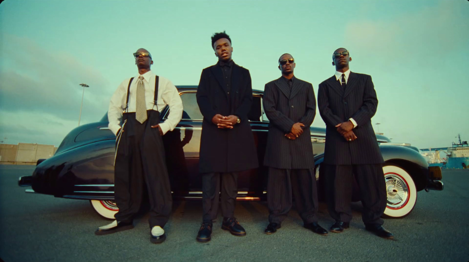 a group of men standing next to each other in front of a car