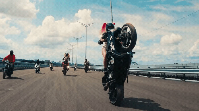 a group of people riding motorcycles down a road