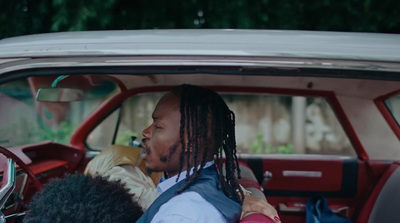 a man with dreadlocks sitting in a car