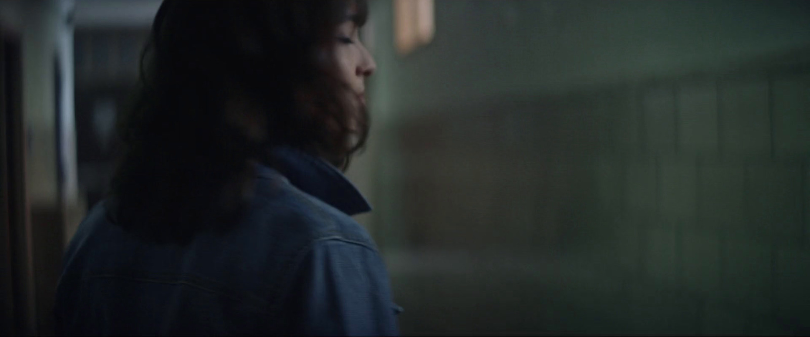 a woman with long hair standing in a hallway