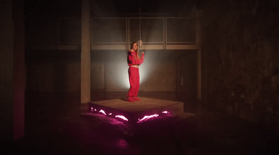 a woman in a red outfit standing on a platform