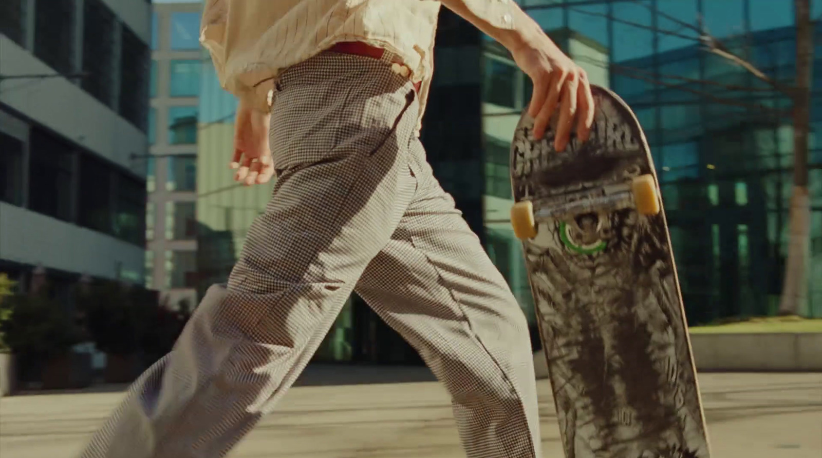 a man walking with a skateboard in his hand