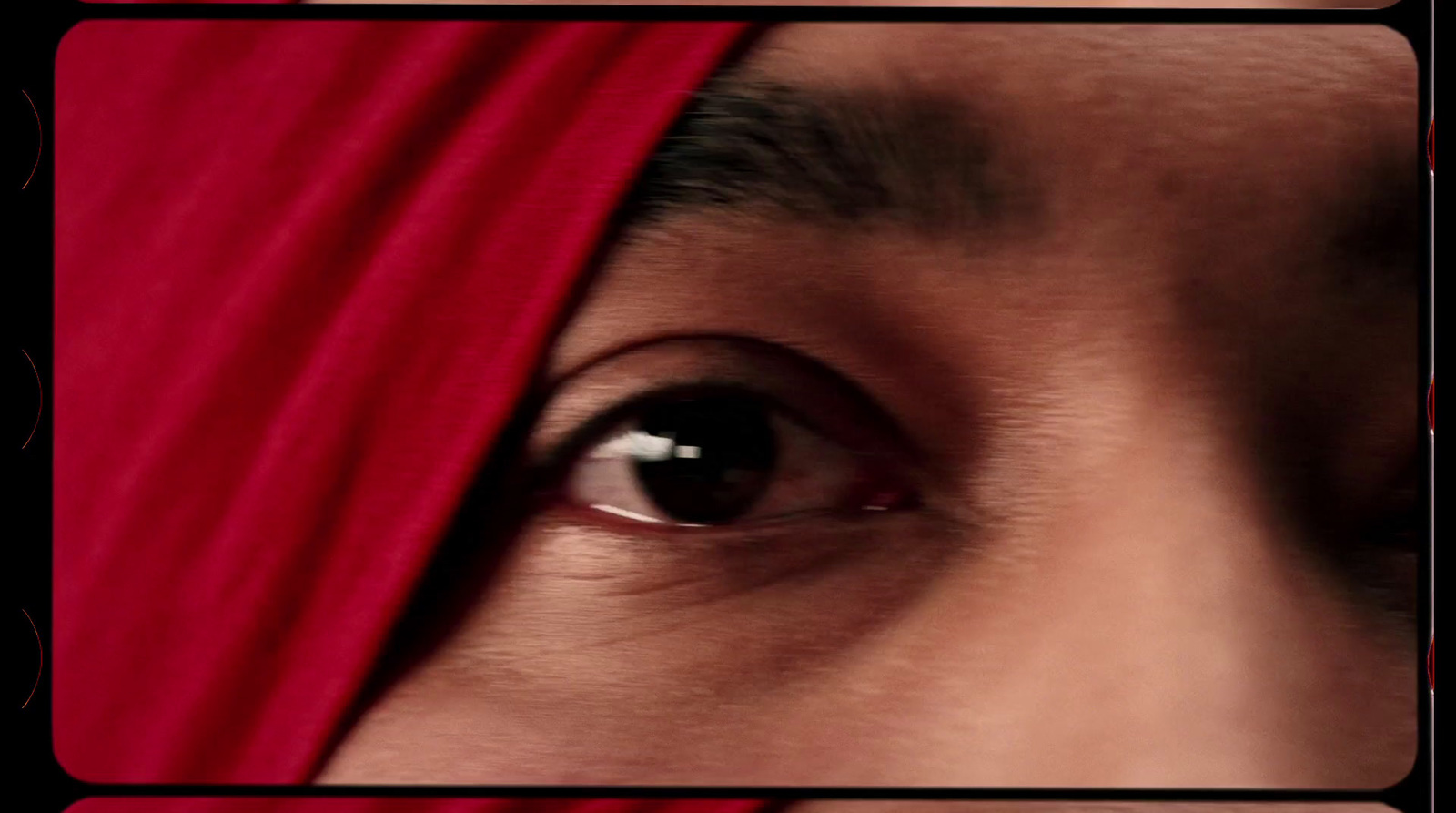 a close up of a person's eye with a red head covering