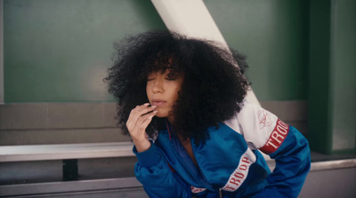 a woman with an afro smoking a cigarette