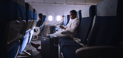 a man sitting on an airplane next to another man