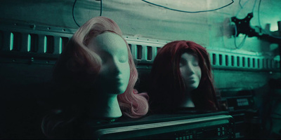 two mannequins with pink hair sitting on top of a shelf