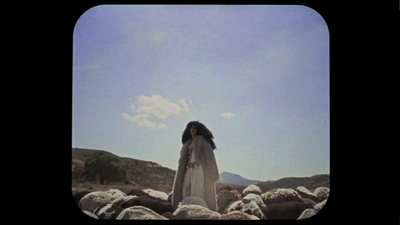 a woman standing on top of a pile of rocks