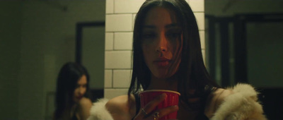 a woman holding a red cup in a bathroom