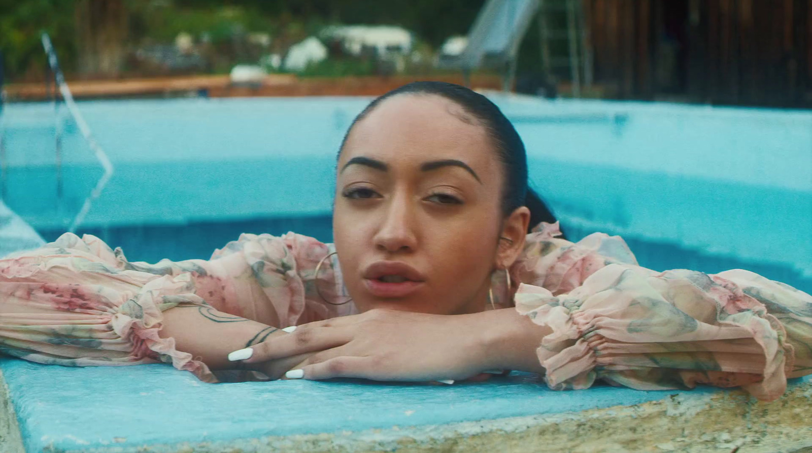 a woman laying in a pool with her hands on her chest