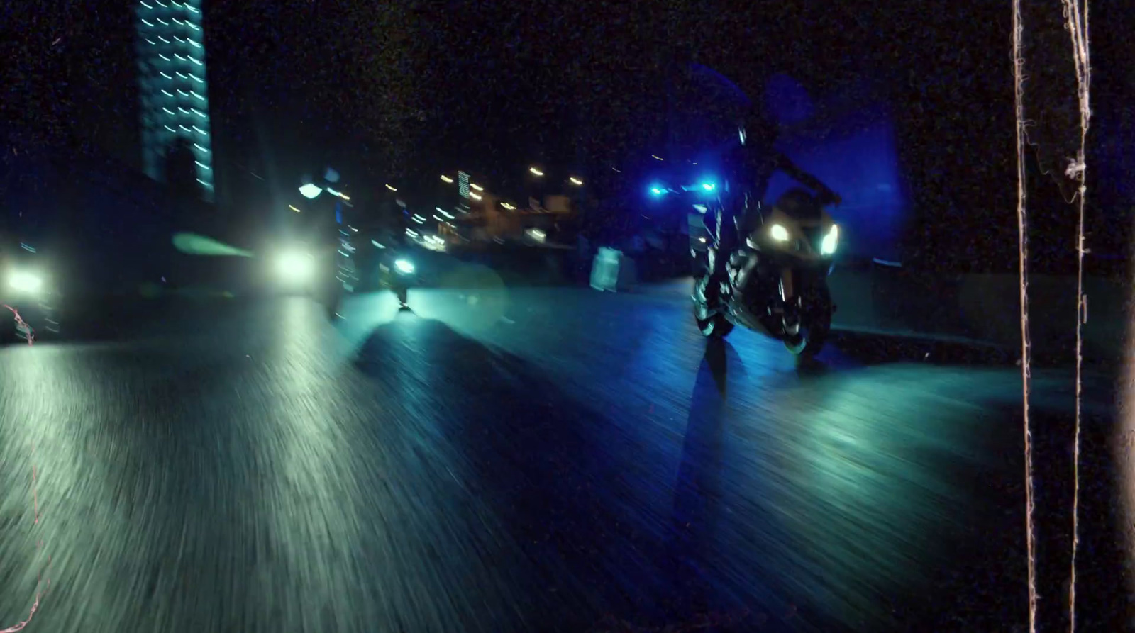 a person riding a motorcycle down a street at night