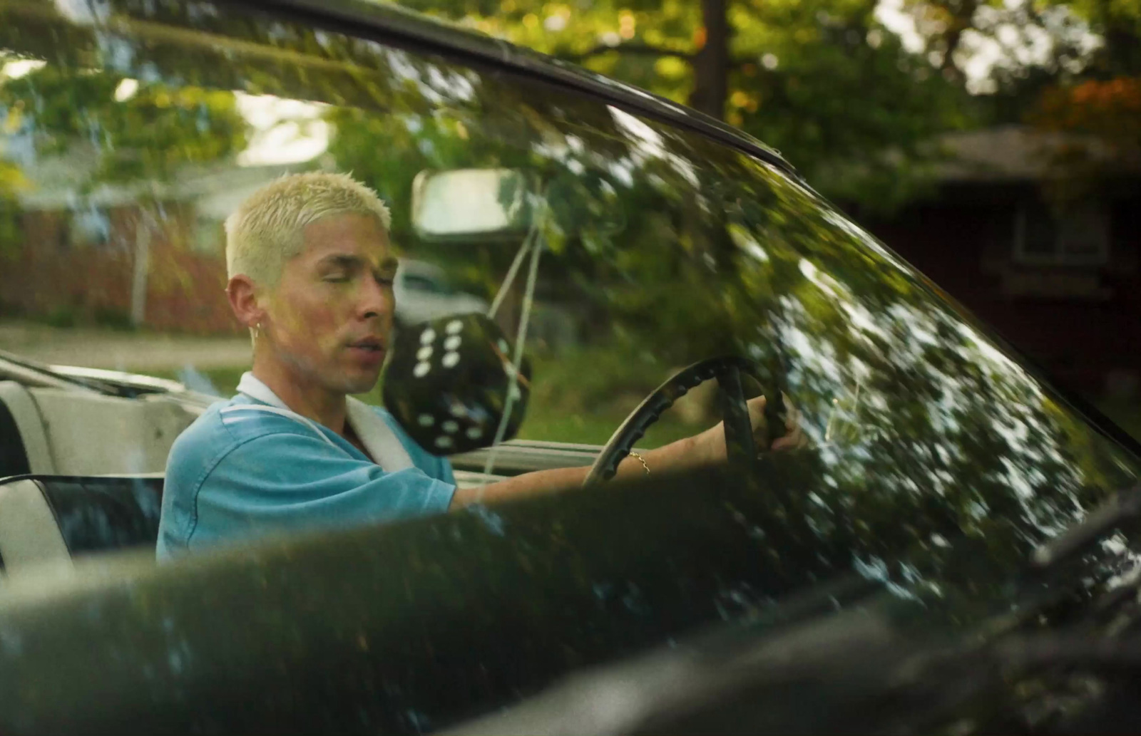 a man driving a car in a driveway