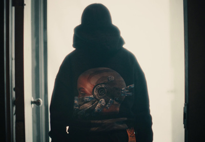 a person standing in a doorway with a hoodie on