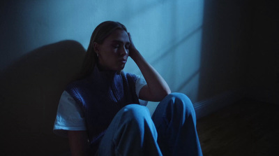 a woman sitting on the floor in a dark room